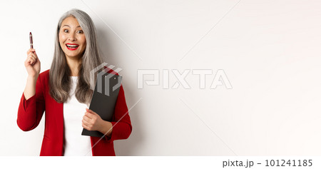 Excellent idea. Happy asian female employer holding clipboard and raising pen with satisfied smile, hear interesting suggestion, standing over white background 101241185