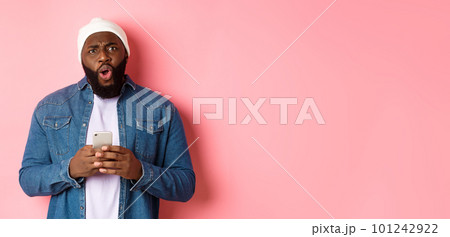 Technology and online shopping concept. Confused and disappointed african-american man complaining, holding mobile phone and staring at camera 101242922
