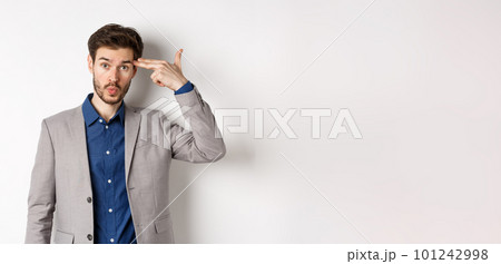Annoyed guy in business suit shoot himself with hand gun near head, look distressed and tired after work, standing on white background Annoyed guy in business suit shoot himself with hand gun near head, look distressed and tired after work, standing on white background 101242998