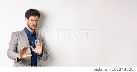 Stay away. Reluctant businessman step back with concerned disgusted face, raising hands to block bad offer, rejecting something awful, telling no and decline proposal, white background 101243620