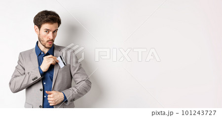 Businessman put credit card in suit pocket and whistling carefree, making shopping, standing on white background Businessman put credit card in suit pocket and whistling carefree, making shopping, standing on white background 101243727