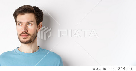Close-up of handsome male model with beard and moustache, looking left with thoughtful face, standing over white background 101244315