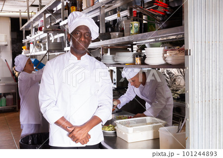 Experienced African American chef of restaurant posing in kitchen 101244893