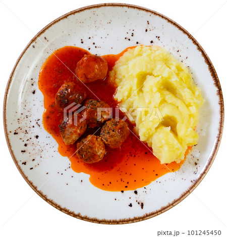 white round plate with meatballs sprinkled with chopped dill in tomato sauce with mashed potatoes 101245450