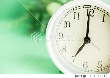 朝7時を表示する目覚まし時計と植物の写真素材 朝7時を表示する目覚まし時計と植物の写真素材 101245519