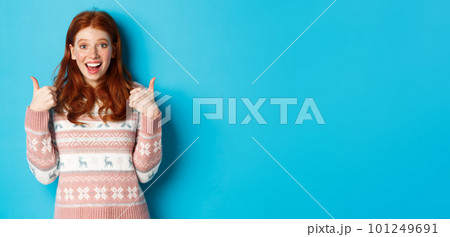 Girl approve something awesome, showing thumb-up, well done gesture and smiling amazed, standing over blue background Girl approve something awesome, showing thumb-up, well done gesture and smiling amazed, standing over blue background 101249691