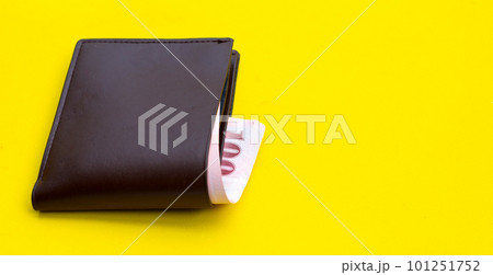 Brown wallet on yellow background Brown wallet on yellow background 101251752