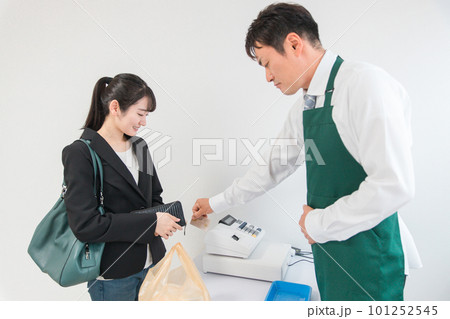 コンビニ・スーパーで買い物をする女性とクレジットカードを端末機に読み取る・スキャンする店員の男性 コンビニ・スーパーで買い物をする女性とクレジットカードを端末機に読み取る・スキャンする店員の男性 101252545