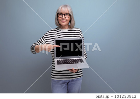 middle aged business woman demonstrates a laptop screen with a mockup for advertising on a bright 101253912