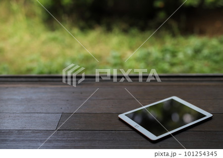 日本の庭園を背景に和室の縁側にタブレットが1台置かれている 101254345