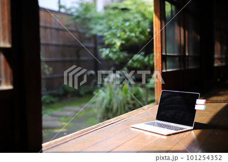 日本の庭園を背景に和室の縁側にパソコンが1台置かれている 101254352