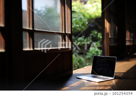 日本の庭園を背景に和室の縁側にパソコンが1台置かれている 101254354