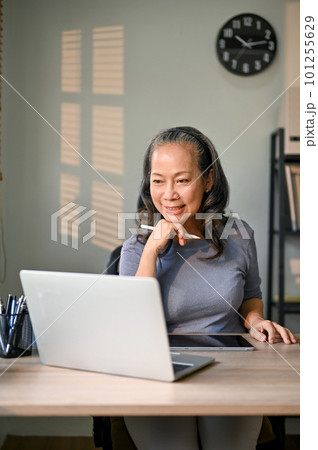 Asian-aged businesswoman working on her business tasks on laptop in her private office. 101255629