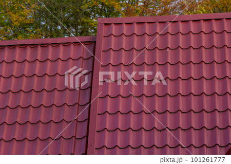 House with new brown metal tile roof and rain gutter. Metallic Guttering System, Guttering and Drainage Pipe Exterior 101261777