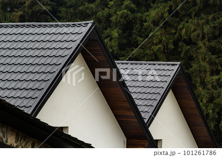 House with new brown metal tile roof and rain gutter. Metallic Guttering System, Guttering and Drainage Pipe Exterior 101261786
