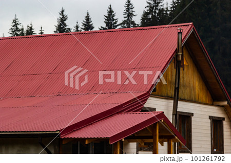 House with new brown metal tile roof and rain gutter. Metallic Guttering System, Guttering and Drainage Pipe Exterior House with new brown metal tile roof and rain gutter. Metallic Guttering System, Guttering and Drainage Pipe Exterior 101261792