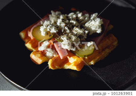 Pizza waffles, piffle. Waffles stuffed with ham cheese, pickled cucumbers on plate Pizza waffles, piffle. Waffles stuffed with ham cheese, pickled cucumbers on plate 101263901