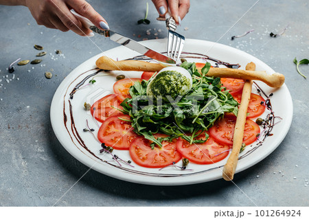 Salad of fresh arugula, tomatoes and soft Italian cheese burrata with green pesto. banner, menu, recipe place for text, top view 101264924