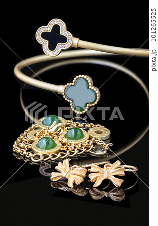 Jewellery Set is isolated on the Black Color Background which has The Gold Bracelet with Jade and Many Precious Diamonds with the Gold Earrings. Jewellery Set is isolated on the Black Color Background which has The Gold Bracelet with Jade and Many Precious Diamonds with the Gold Earrings. 101265525