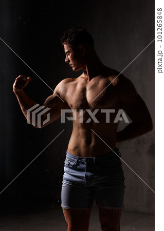 Athlete bodybuilder trains in the studio in the rain. 101265848
