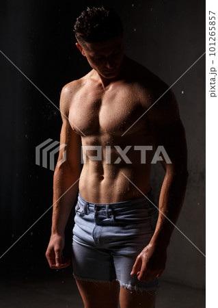 Athlete bodybuilder trains in the studio in the rain. 101265857