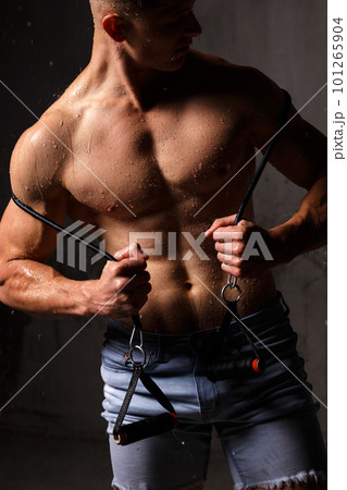 Athlete bodybuilder trains in the studio in the rain. Athlete bodybuilder trains in the studio in the rain. 101265904