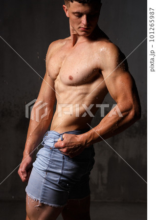 Athlete bodybuilder trains in the studio in the rain. 101265987