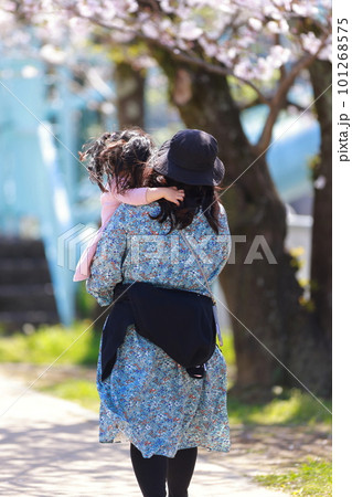 桜並木を子供を抱きかかえて散歩する女性 桜並木を子供を抱きかかえて散歩する女性 101268575