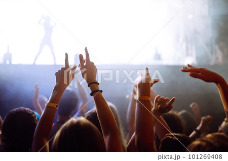 Crowd with raised hands at music festival. Fans enjoying rock concert with light show, clapping. Crowd with raised hands at music festival. Fans enjoying rock concert with light show, clapping. 101269408