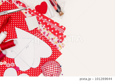 Set for sewing hearts on a light background with copy space. Handmade for valentine's day or mother's day. Pattern for sewing, fabric, lace, thread, buttons, sequins and scissors. Set for sewing hearts on a light background with copy space. Handmade for valentine's day or mother's day. Pattern for sewing, fabric, lace, thread, buttons, sequins and scissors. 101269644