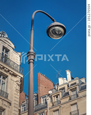 Retro style street lamp in an old Paris district with view to the blue sky background Retro style street lamp in an old Paris district with view to the blue sky background 101270504