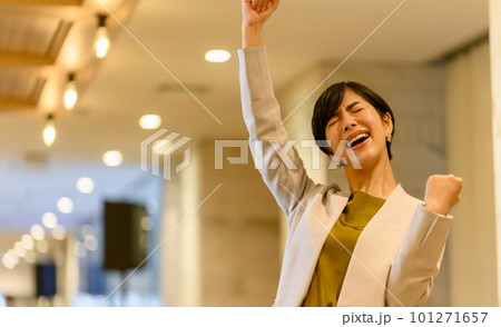 オフィスのロビーでガッツポーズをする女性 101271657