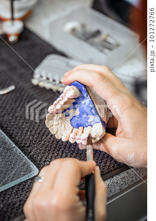 Dental technician applying ceramics 101272766