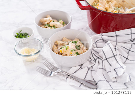 Chicken alfredo pasta with green peas and rigatoni pasta in a small bowl. Chicken alfredo pasta with green peas and rigatoni pasta in a small bowl. 101273115