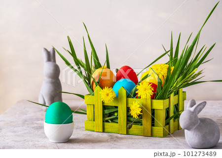 Easter spring decoration with painted eggs, rabbits, field flowers, wooden box and wheatgrass Easter spring decoration with painted eggs, rabbits, field flowers, wooden box and wheatgrass 101273489