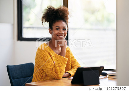 African american student woman in sweater using digital tablet t 101273897