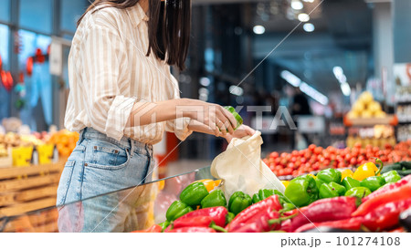 Woman picking bell peppers in a reusable bag. Ecology, Earth Day thematics Woman picking bell peppers in a reusable bag. Ecology, Earth Day thematics 101274108