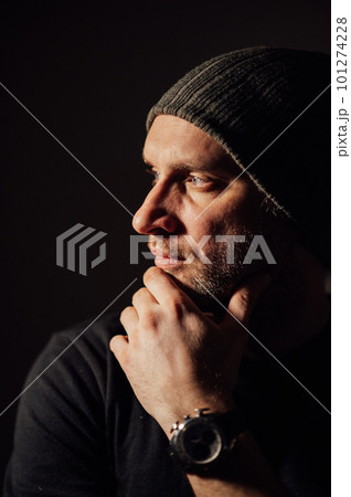 Serious dramatic man looking away while standing against black studio background 101274228