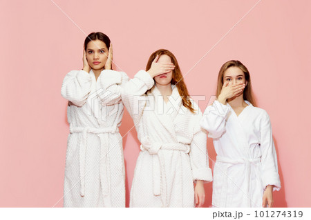Three girls in bathrobes covering eyes, mouth and ears, posing against pink studio background. Keeping secrets Three girls in bathrobes covering eyes, mouth and ears, posing against pink studio background. Keeping secrets 101274319