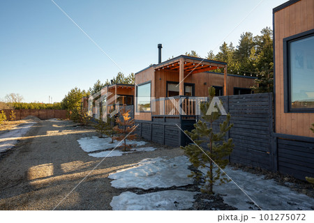 A wooden cabin with a small tree in the foreground and a small tree in the background. A wooden cabin with a small tree in the foreground and a small tree in the background. 101275072