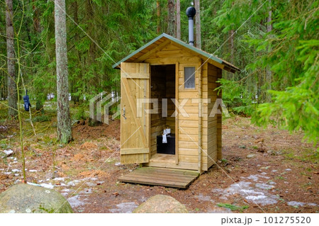 Wooden outdoor toilet in the forest with an open door. toilet paper roll. Wooden outdoor toilet in the forest with an open door. toilet paper roll. 101275520