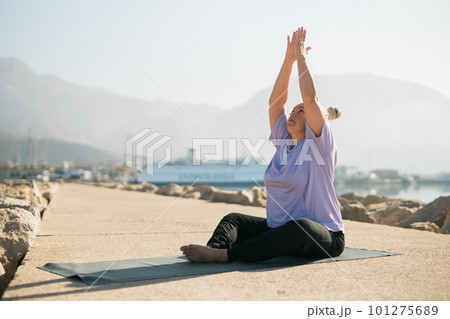 Mature old woman with dreadlocks practicing yoga and tai chi outdoors by the sea - wellbeing and wellness Mature old woman with dreadlocks practicing yoga and tai chi outdoors by the sea - wellbeing and wellness 101275689