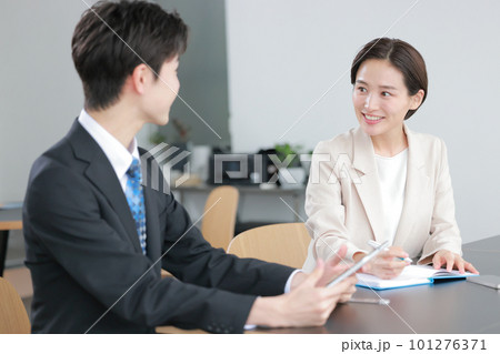 にこやかに打ち合わせするスーツの男女2 101276371