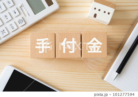 手付金と書かれたブロック、電卓、家の模型、スマホ、ノート 101277594