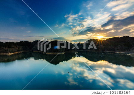 長秒露光による流ていく雲と鏡のような水面(沈み行く太陽)　2023年春奈良布目ダムにて 101282164