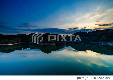 長秒露光による流ていく雲と鏡のような水面(山際に沈んだ太陽)　2023年春奈良布目ダムにて 101282169