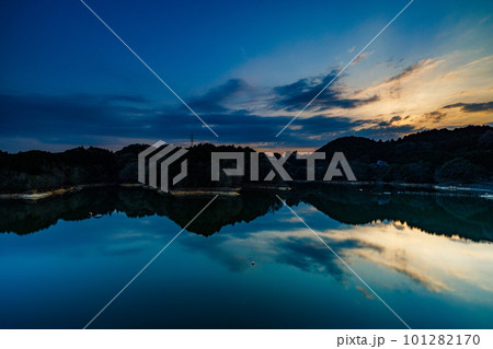 長秒露光による流ていく雲と鏡のような水面(山際に沈んだ太陽)②　2023年春奈良布目ダムにて 101282170