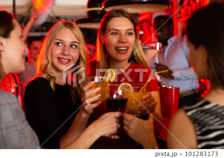 Female friends enjoying wine in night club Female friends enjoying wine in night club 101283173