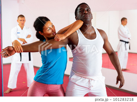 Portrait of woman during self-defense training at sports club. Sparring with male partner Portrait of woman during self-defense training at sports club. Sparring with male partner 101283218