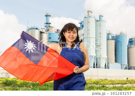 Happy asian girl in work clothes with flag of taiwan standing in front of industrial scenery 101283257